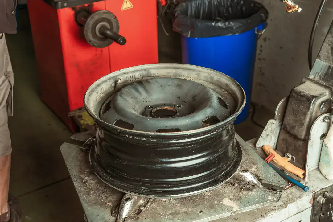 Hjulskift på bil i autoværksted med værktøj og udstyr.