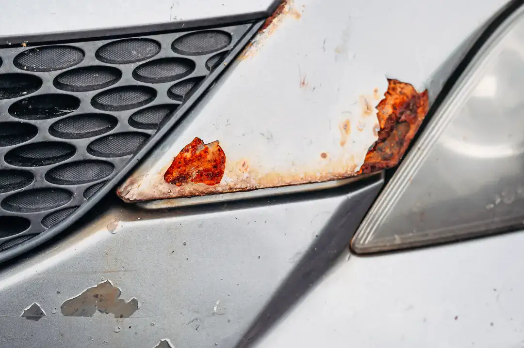 Rustent bilkarosseri med rustpletter og skader.