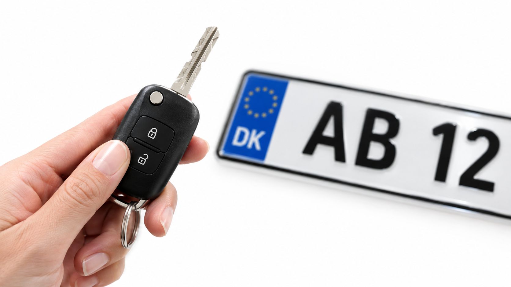 Billedet viser en hånd, der holder en bilnøgle og en dansk nummerplade.